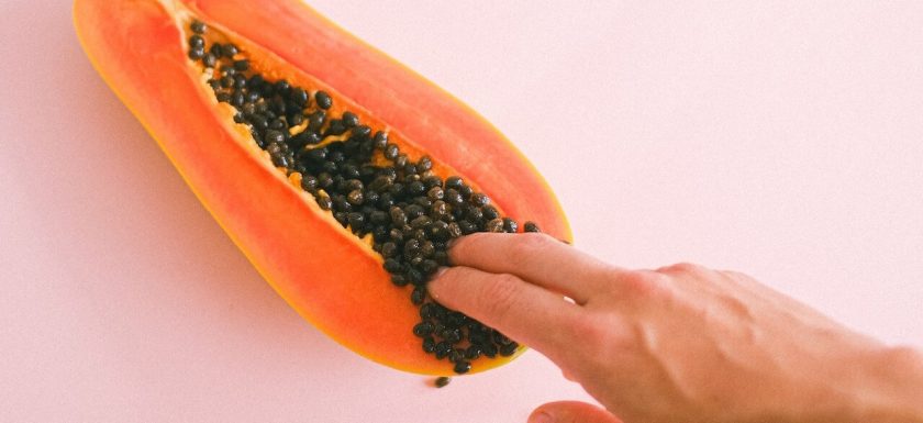 An image of two fingers inside a papaya.